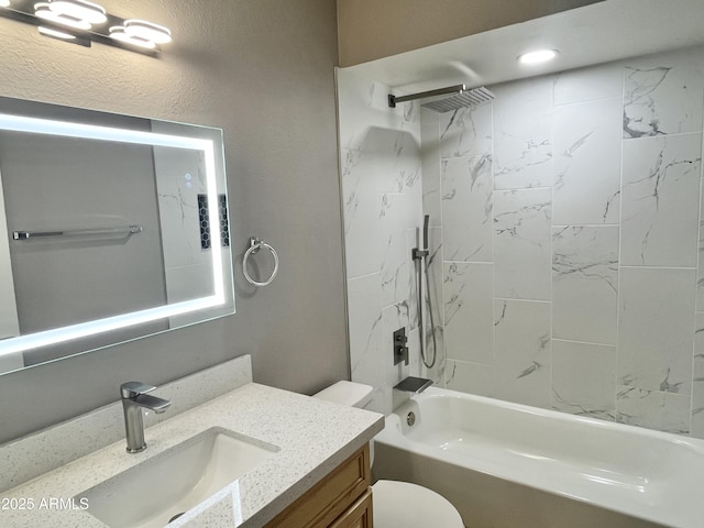 full bathroom featuring tiled shower / bath, vanity, and toilet