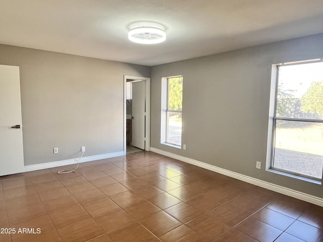 tiled empty room featuring plenty of natural light