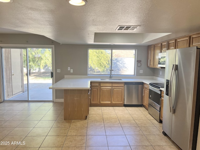 kitchen with light tile patterned floors, a textured ceiling, stainless steel appliances, and sink