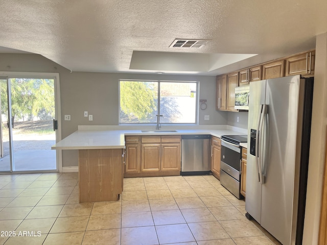 kitchen with kitchen peninsula, appliances with stainless steel finishes, light tile patterned flooring, and sink