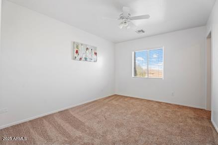 unfurnished room with carpet flooring and ceiling fan