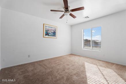 carpeted spare room featuring ceiling fan