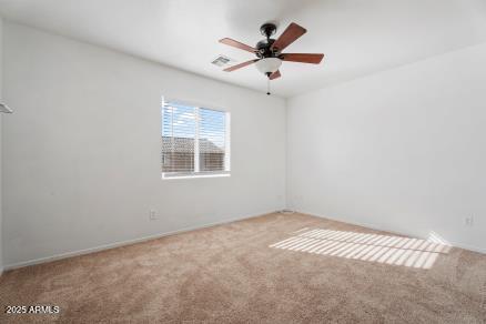 carpeted spare room featuring ceiling fan