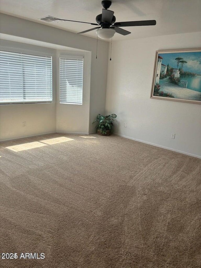 carpeted spare room featuring ceiling fan