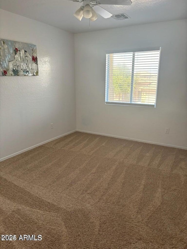 carpeted spare room featuring ceiling fan