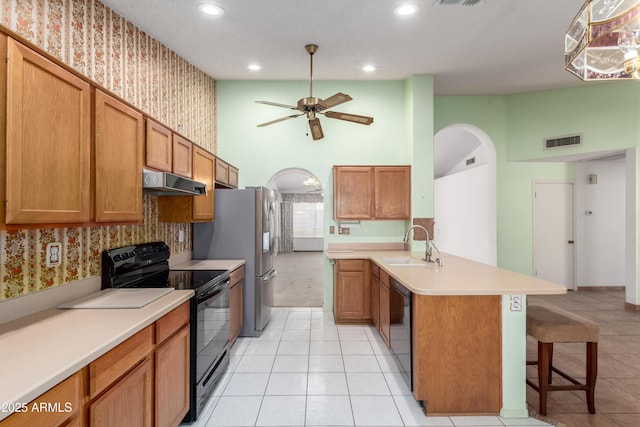3140 N 114th Dr, Avondale, AZ 85392 - kitchen featuring under cabinet range hood, visible vents, wallpapered walls, and black appliances