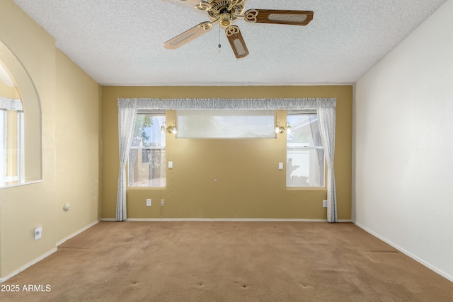 3140 N 114th Dr, Avondale, AZ 85392 - carpeted spare room with a textured ceiling, baseboards, a ceiling fan, and arched walkways