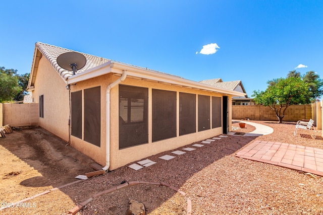 3140 N 114th Dr, Avondale, AZ 85392 - back of property featuring a sunroom, a patio, a fenced backyard, and stucco siding