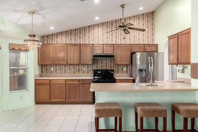 3140 N 114th Dr, Avondale, AZ 85392 - kitchen featuring brown cabinetry, stainless steel fridge, electric range, and under cabinet range hood