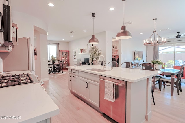 kitchen featuring an island with sink, a breakfast bar, white cabinetry, and a healthy amount of sunlight