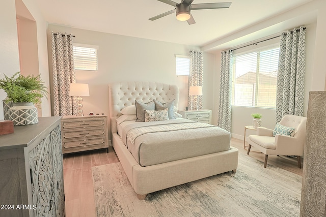 bedroom with multiple windows, wood-type flooring, and ceiling fan