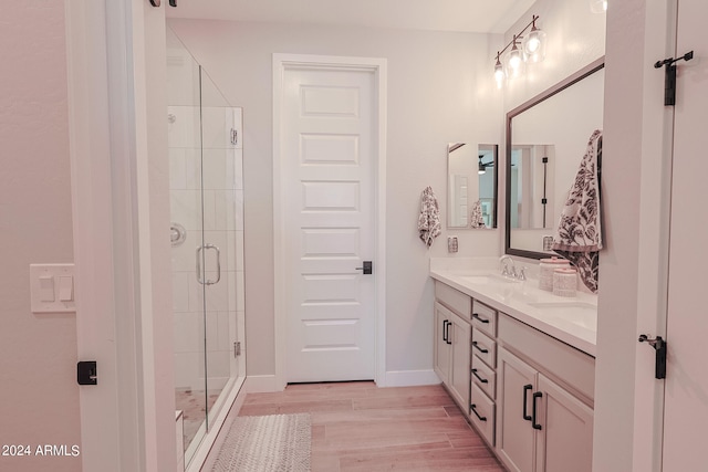 bathroom with wood-type flooring, walk in shower, and vanity