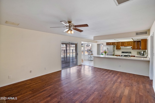 unfurnished living room featuring ceiling fan, sink, and tile floors