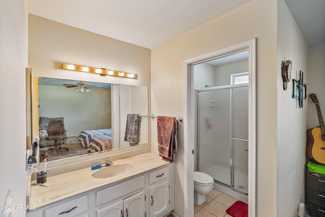 bathroom with oversized vanity, toilet, an enclosed shower, ceiling fan, and tile floors