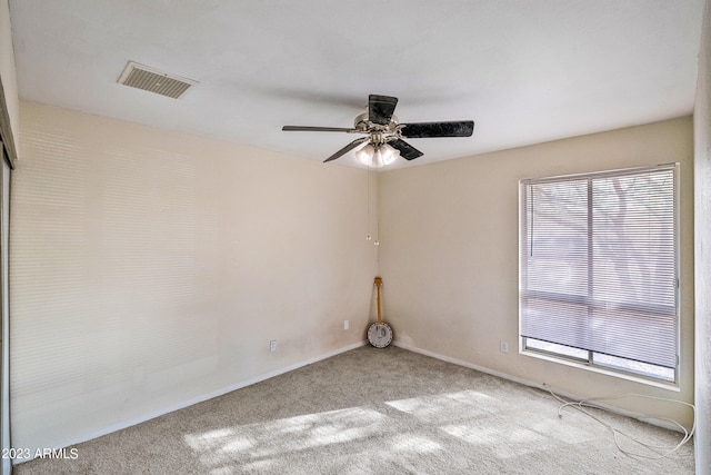 carpeted spare room with plenty of natural light and ceiling fan