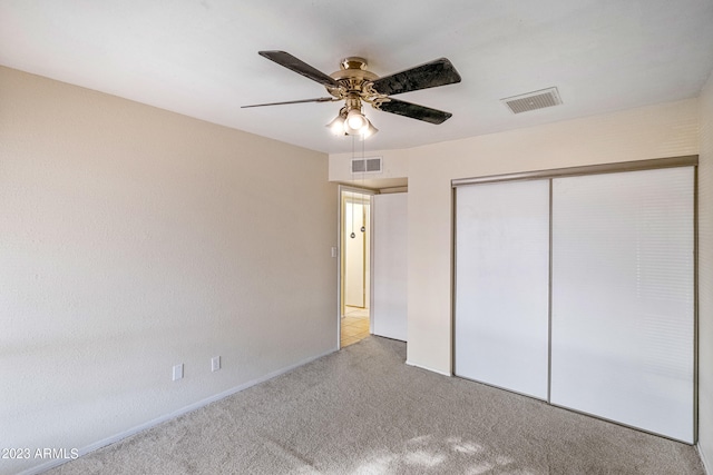 unfurnished bedroom with ceiling fan, a closet, and light colored carpet