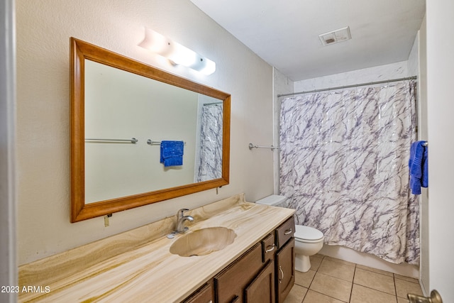 bathroom featuring tile flooring, toilet, and vanity