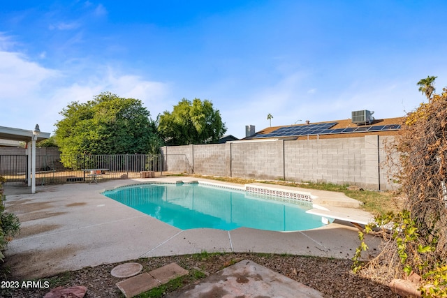 view of pool with a patio, central air condition unit, and a diving board