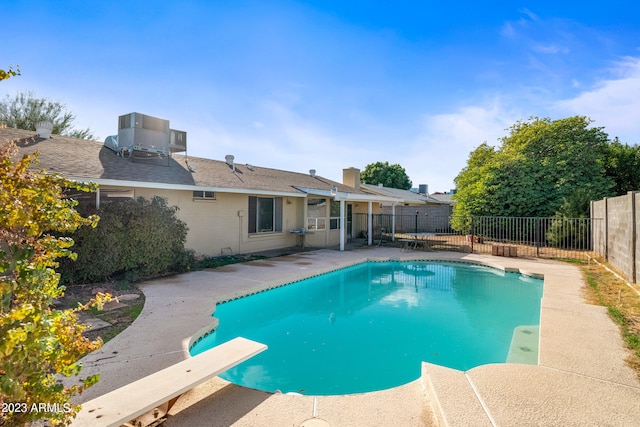 view of swimming pool featuring a diving board and a patio