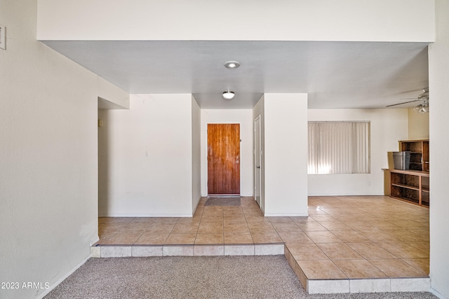 carpeted foyer featuring ceiling fan