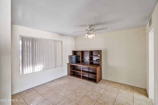 empty room featuring light tile floors and ceiling fan