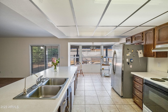 kitchen featuring light tile floors, electric range, stainless steel refrigerator, and sink