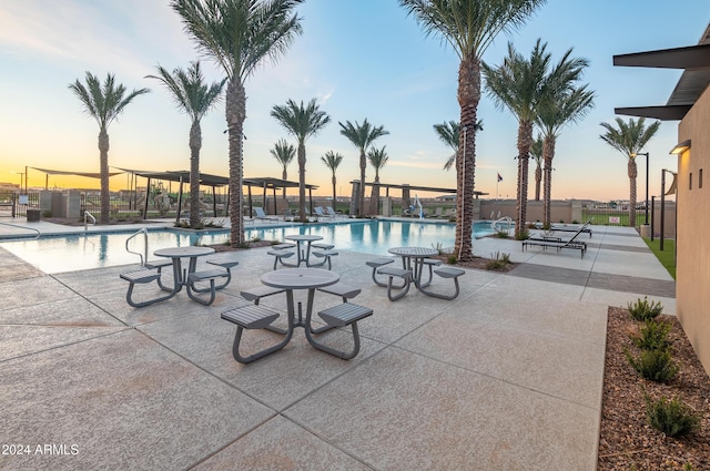 community pool with a patio area and fence