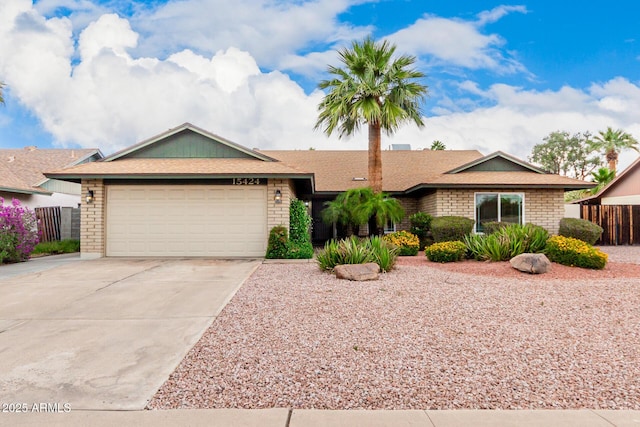 15424 N 52nd Pl, Scottsdale, AZ 85254 - ranch-style home with concrete driveway, an attached garage, brick siding, fence, and roof with shingles