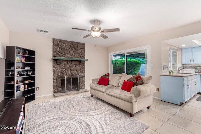 15424 N 52nd Pl, Scottsdale, AZ 85254 - living room featuring a ceiling fan, light tile patterned floors, and a stone fireplace
