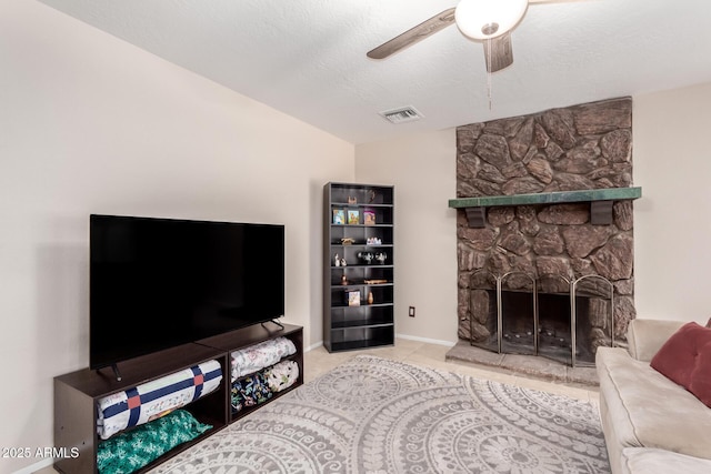 15424 N 52nd Pl, Scottsdale, AZ 85254 - tiled living area with a fireplace, a ceiling fan, a textured ceiling, and baseboards