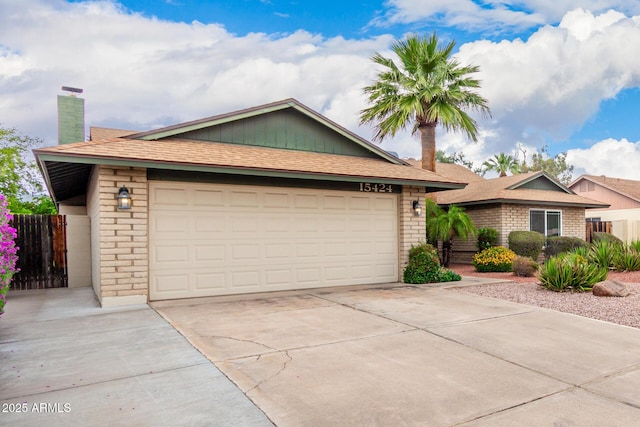 15424 N 52nd Pl, Scottsdale, AZ 85254 - ranch-style house featuring a chimney, concrete driveway, fence, a garage, and brick siding