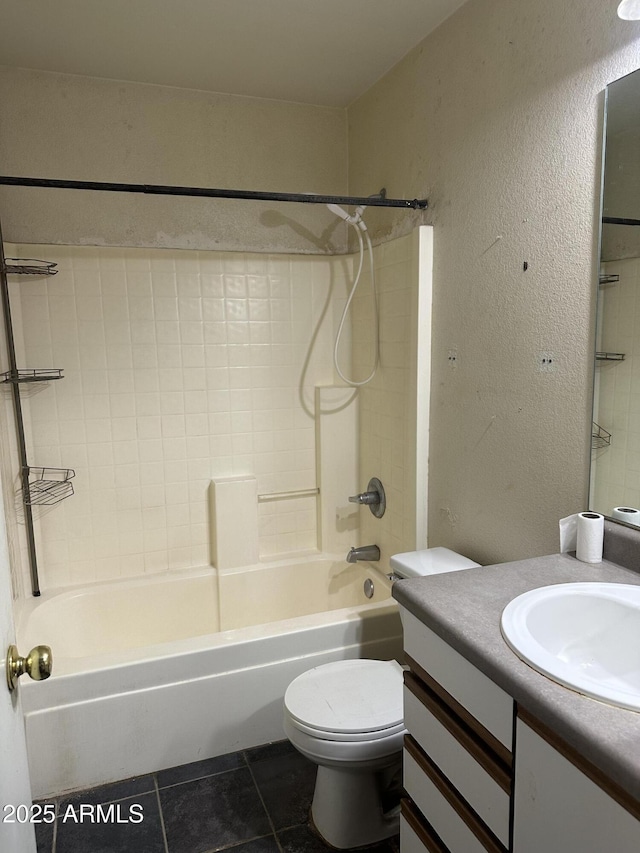 bathroom featuring bathing tub / shower combination, a textured wall, toilet, vanity, and tile patterned floors