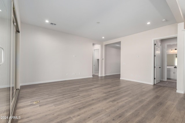 unfurnished bedroom featuring hardwood / wood-style flooring and ensuite bath