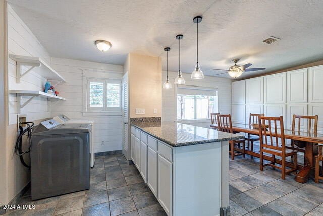 laundry room featuring ceiling fan, separate washer and dryer, and a textured ceiling