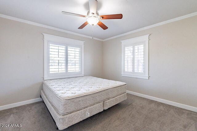 carpeted bedroom with crown molding and ceiling fan