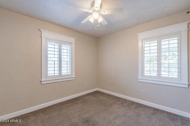 carpeted spare room featuring ceiling fan