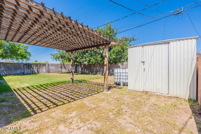 view of yard with a pergola and a shed