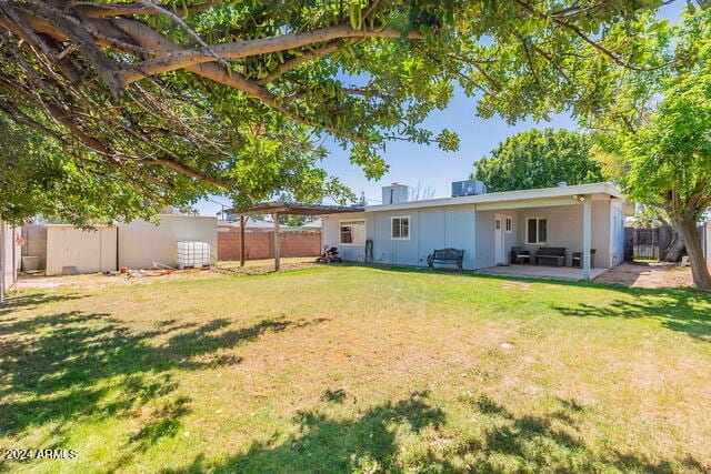 rear view of house with a yard and a patio