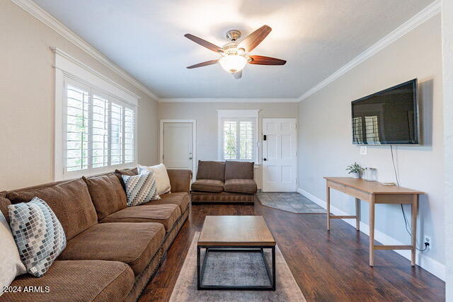 living room featuring ceiling fan, crown molding, and dark hardwood / wood-style floors