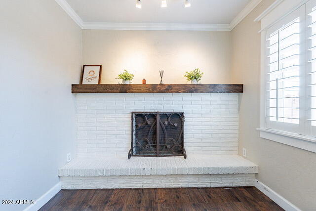 room details featuring a brick fireplace, hardwood / wood-style flooring, and ornamental molding