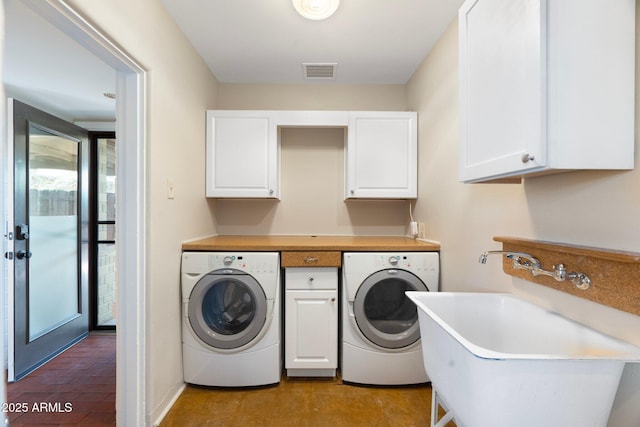 clothes washing area with cabinets, sink, and separate washer and dryer