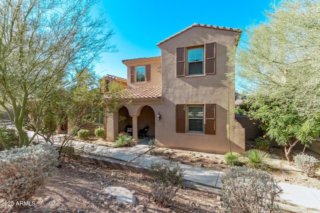 mediterranean / spanish-style home featuring a tile roof and stucco siding