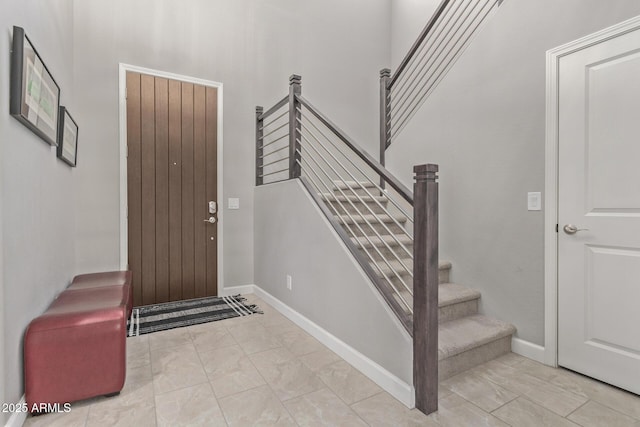 foyer with stairs and baseboards