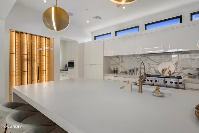 24863 N 103rd Way, Scottsdale, AZ 85255 - kitchen with tasteful backsplash, appliances with stainless steel finishes, white cabinets, light countertops, and hanging light fixtures