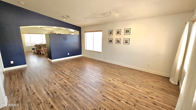 3002 W Caravaggio Ln, Phoenix, AZ 85086 - spare room featuring arched walkways, wood finished floors, and baseboards