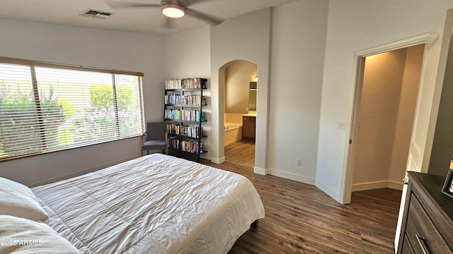 3002 W Caravaggio Ln, Phoenix, AZ 85086 - bedroom with dark wood-type flooring, arched walkways, baseboards, ensuite bathroom, and a ceiling fan