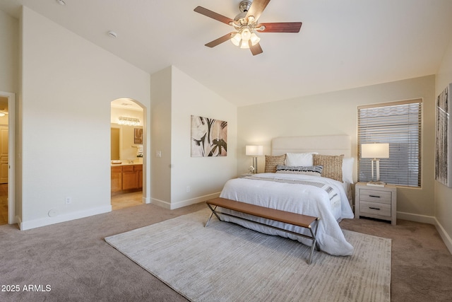 bedroom featuring high vaulted ceiling, ensuite bath, light carpet, and ceiling fan