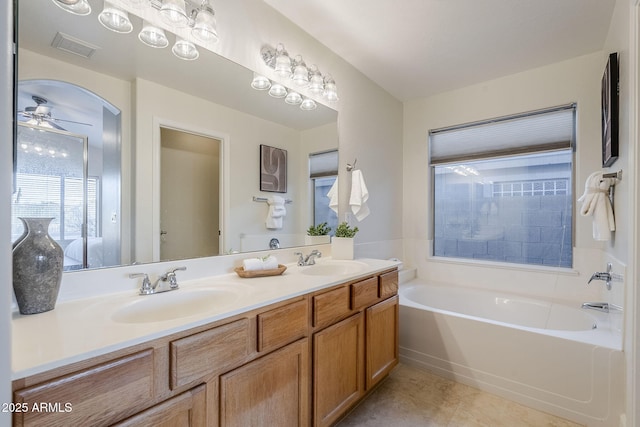 bathroom with vanity, ceiling fan, and a bathtub