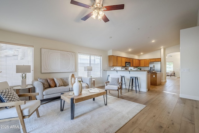 living room featuring light hardwood / wood-style floors, ceiling fan, and lofted ceiling