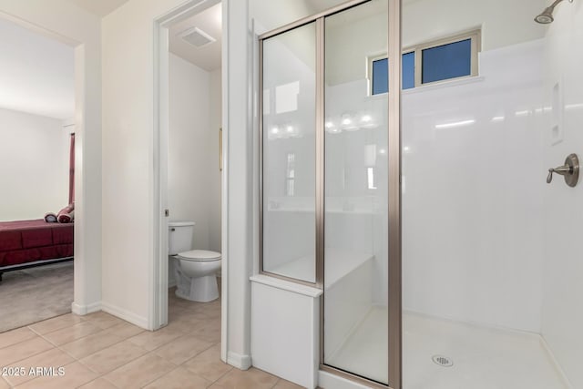 bathroom with tile patterned floors, toilet, and an enclosed shower